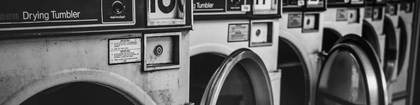 Grimy tumble dryers in a laundrette (laundromat).